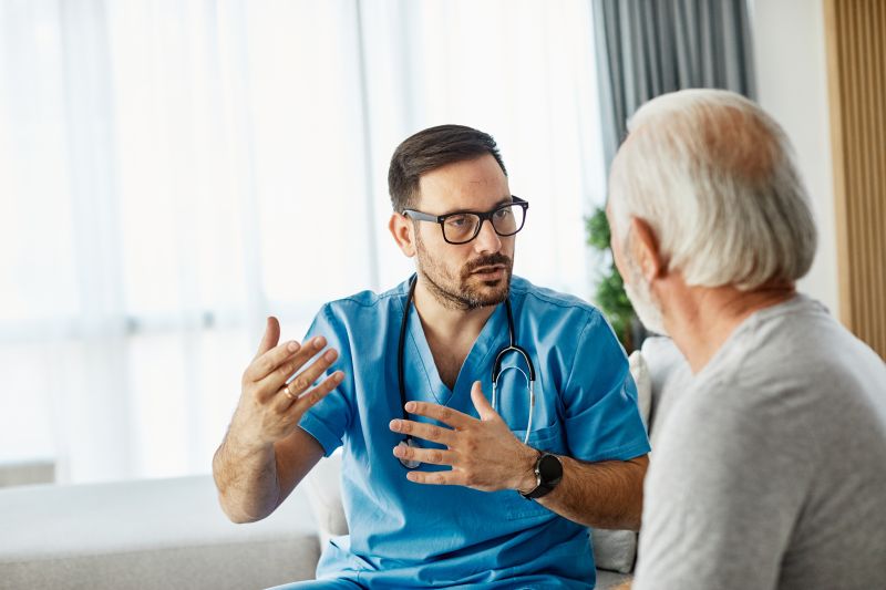 healthcare professional speaking with older patient, animatedly